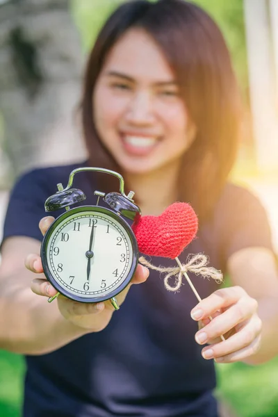 Amour et temps, Thai asiatique mignon adolescent fille femme tenir horloge et coeur rouge dans le parc vert . — Photo