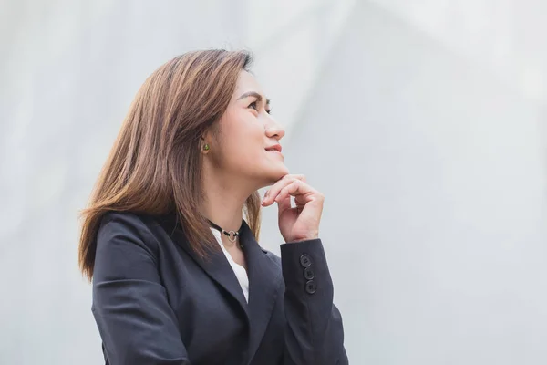 Asian working woman think or business girl thinking with building architecture background. — Stock Photo, Image