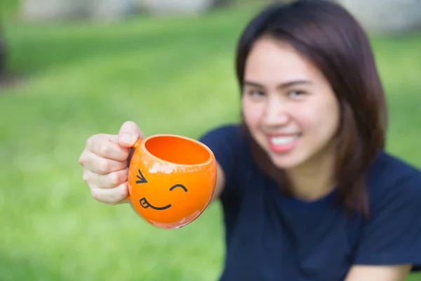 Gelukkig drankje concept, Aziatische tiener handvat glimlach mok in het park. — Stockfoto