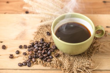Aroma sıcak siyah kahve veya duman tahta arka plan ile Americano ve Arabica kahve çekirdeği.