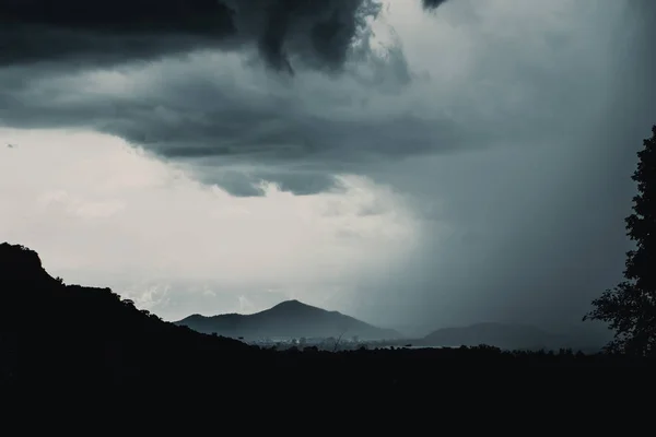 Silueta hory Dark zataženo, déšť bouře pršet na krajinu sky. — Stock fotografie