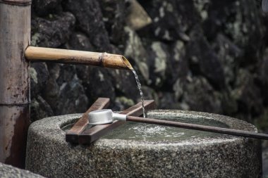 Japonca Tapınağı'nda taş küvette bambu boruyla su durulama.