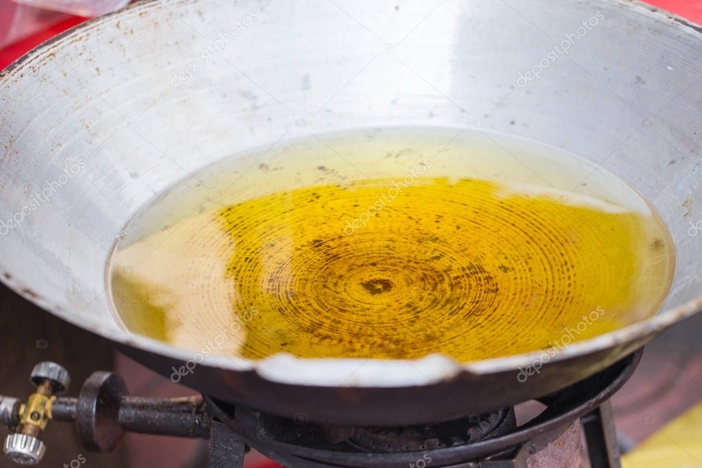 used plam food oil in street kitchen stall frying pan.