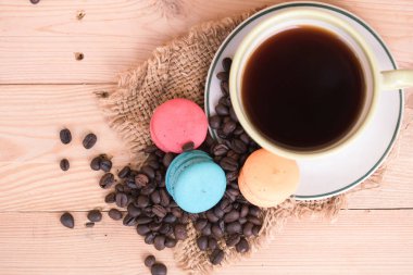 siyah kahve ve macarons ahşap masa üzerinde.