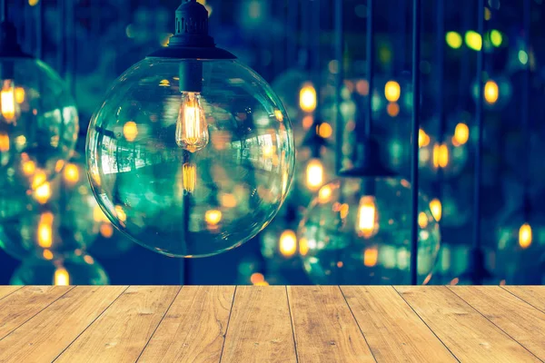 Wood floor with hang vintage light bulb background. — Stock Photo, Image