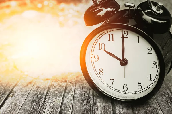 Vieux concept de temps de mémoire, horloge rétro chronométrée à 10 heures sur bois avec lumière du soleil . — Photo