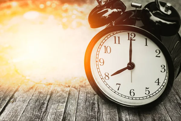 Viejo concepto de tiempo de memoria, reloj retro cronometrado a las 8 en punto en madera con luz solar . —  Fotos de Stock