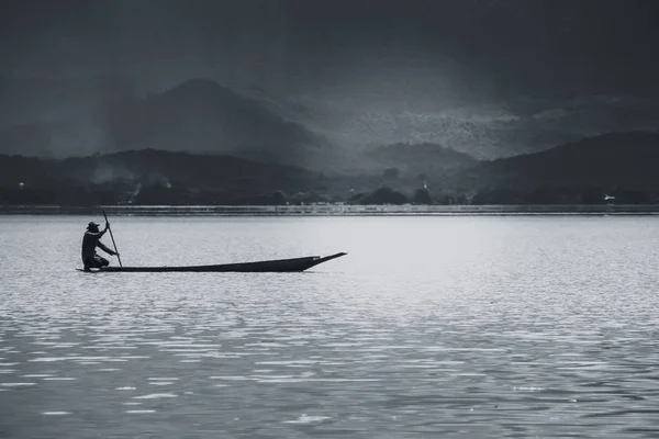 Empty wooden fisherman fishing boat in quiet lake sky black and white tone. — Stock Photo, Image