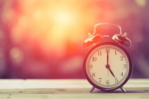 5 heures Horloge classique Vintage couleur rétro ton sur table en bois avec lumière du soleil — Photo