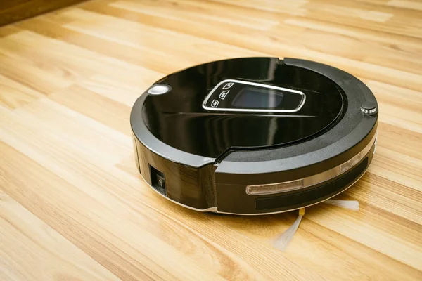 Robot vacuum cleaner on laminate wood floor — Stock Photo, Image