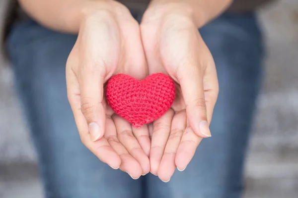 Dávat lásku. červené srdce u žen její ruku — Stock fotografie
