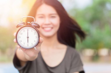 Asyalı kadın el göstermek saat kez saat 6'da, bir şeyler yapmak zamanı kavramı.