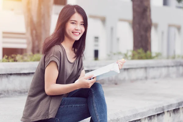 Universidad universitaria adolescente niña lectura y educación. Hermosa mujer asiática estudio leer el libro en la mañana . — Foto de Stock