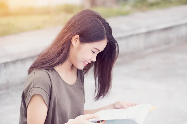 亚洲青少年女性阅读本书快乐，微笑还享受大学教育. — 图库照片