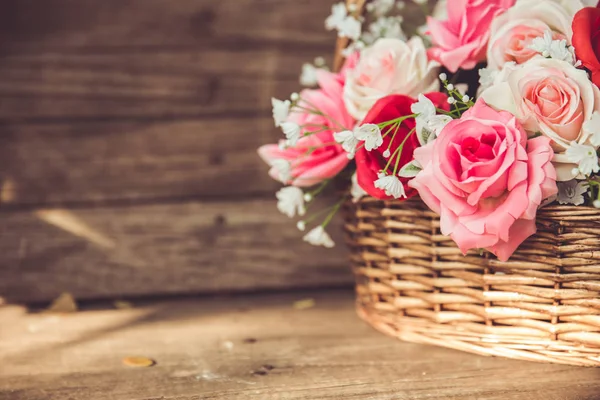 Vintage bloem roos in de mand op oude houten achtergrond. — Stockfoto
