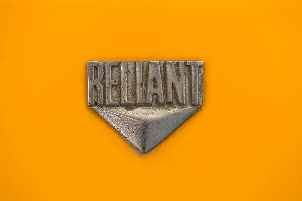 "Reliant "Vintage mini bil logotyp av brittiska biltillverkare som producerar 3-hjuliga Reliant Robin bilar mellan 1970 och 1990. — Stockfoto
