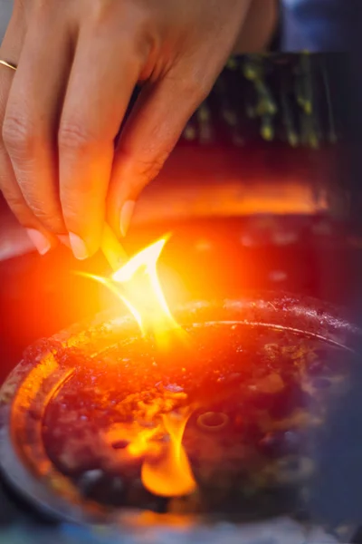 Tänds ljuset, handen håll ljus eld från oljelampa i thailändska tempel. — Stockfoto