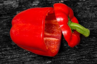 koyu ahşap arka plan üzerinde kesme portre kırmızı dolmalık biber.