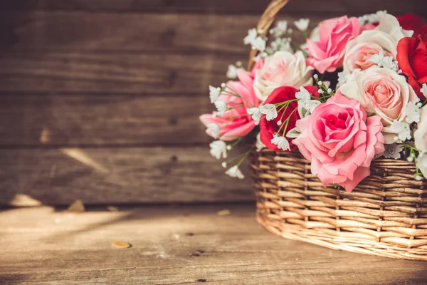 Vintage bloem roos in de mand op oude houten achtergrond. — Stockfoto
