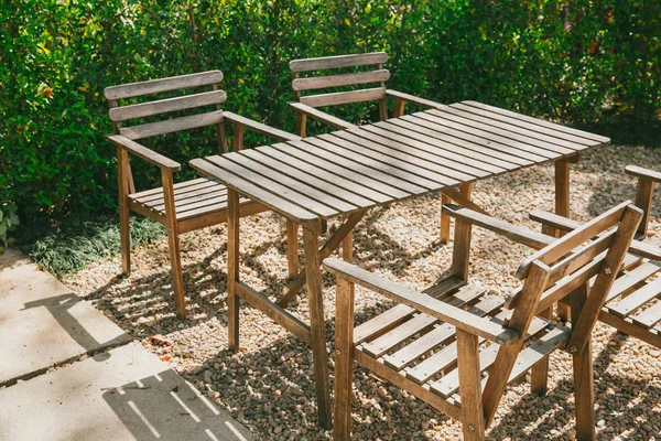 Pusty stół z drewna w ogrodzie, obiad w restauracji na wolnym powietrzu park. — Zdjęcie stockowe