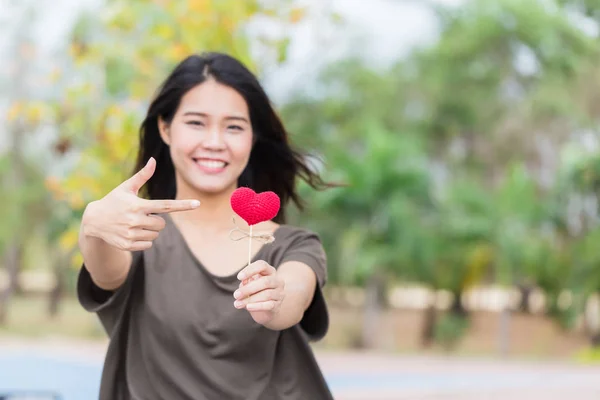 Asyalı kadın elini tut tatlı dikkatli ya da hayırseverlik yardım sizin için sembol sevmek güzel kırmızı kalp. — Stok fotoğraf