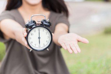 Kez parayı ödemek için fatura veya şimdi vergi kavramı bana bir şey vermek zamanı, Asyalı kadınlar el avuç ve retro saat saat 6'da tutun.