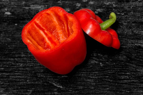 Primer plano pimiento rojo cortado sobre fondo de madera oscura . —  Fotos de Stock