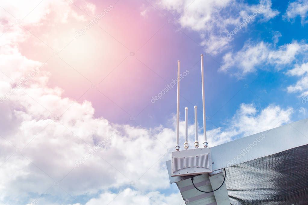WIFI antenna outdoor at roof hotspot long range digital data signal transport against blue sunny day sky