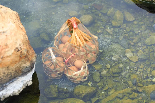 Natural Hervir Huevos para alimentos minerales, hirviendo en la naturaleza agua caliente con cesta. Hervido en aguas termales . — Foto de Stock