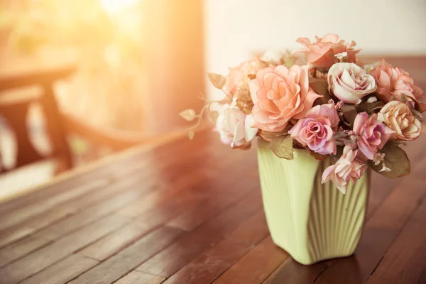 Mooie roze bloempot op houten tafel natuur huis decoratie met zon licht vintage kleurtoon. — Stockfoto