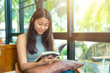 Zevk kez kitap okumak, kahve dükkanı vintage renk tonu kitapta Asyalı kadınlar Taylandlı teen gülümsemeyle ile rahatla