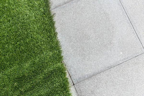 Зелена трава з бетонним фоном — стокове фото