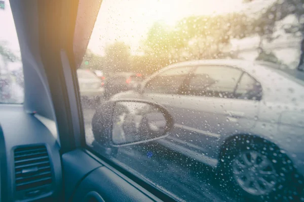 Αυτοκίνητο σε βρέχει σεζόν. όχημα πλευρικά παράθυρα με βροχή σταγόνες νερό και ήλιο φόντο. — Φωτογραφία Αρχείου