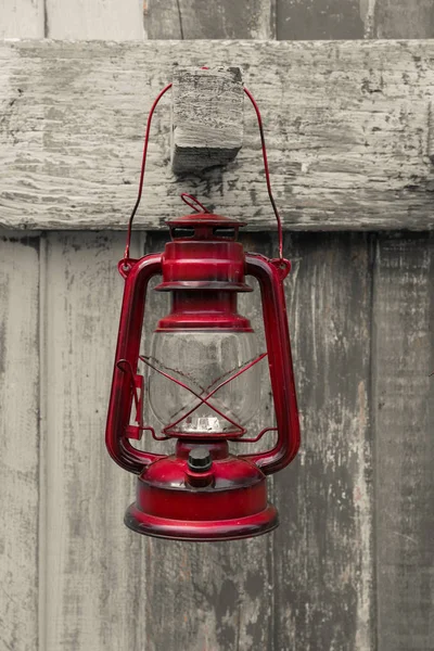 Western-style olie lantaarn, rode oude lamp vintage stijl hangen houten achtergrond. — Stockfoto