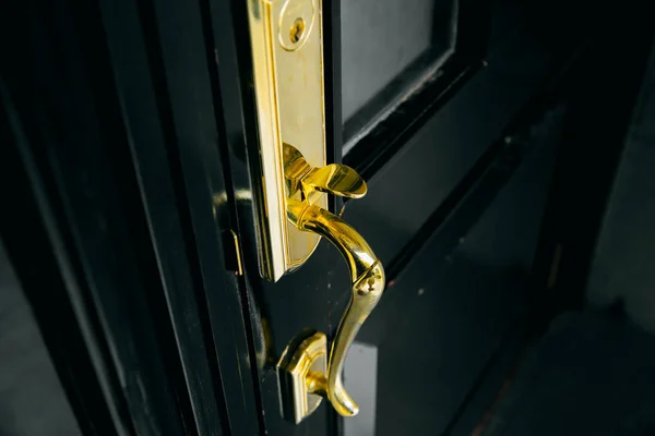 Luxury door golden handle shiny with black wood door. — Stock Photo, Image