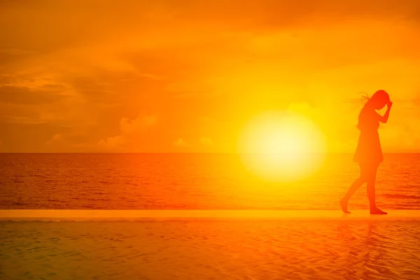 Women walk away. silhouette of girl on the beach with summer sea beautiful sunset background — Stock Photo, Image