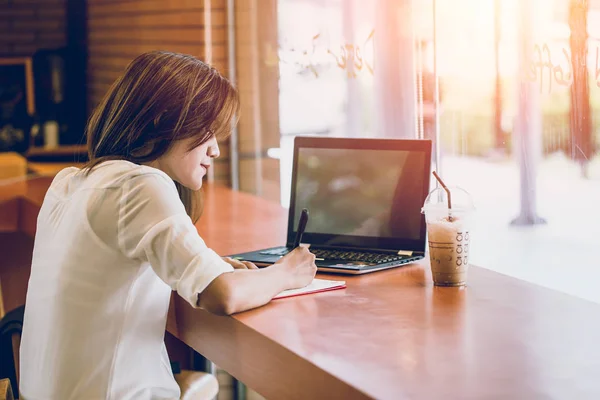 Asian women woking at the cafe with laptop and writing note. thinking business project action. — Stock Photo, Image