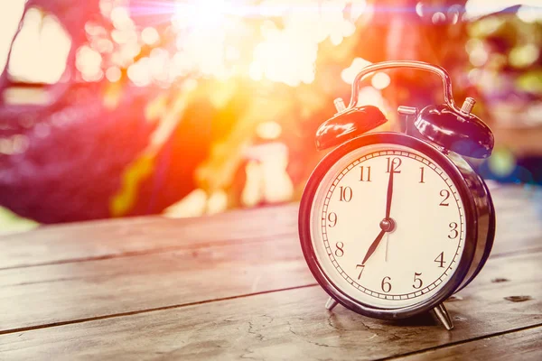 Horloge sur table en bois avec effet soleil le matin à 7 heures . — Photo