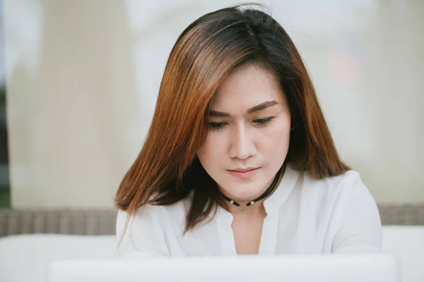 Asiático mujeres profesional trabajo duro mirando abajo en portátil pantalla en trabajo oficina . — Foto de Stock