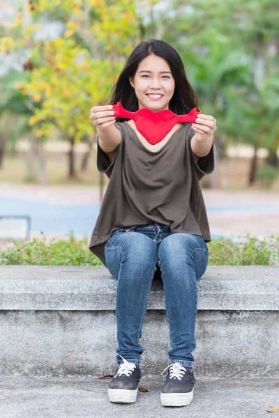 Ázsiai nő kezében tartsa gyönyörű piros szív édes szerető a szimbólum a take care vagy jótékonysági segítségre van szüksége. — Stock Fotó