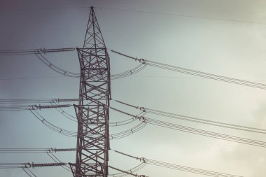 Yüksek gerilim kablo güç sonrası çelik kule dikmesi vintage renk tonu siluet.