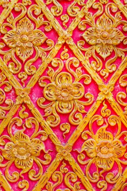 Tayland Çiçek deseni kabartma çimento boya tapınakta altın ve kırmızı renkli arka planla.