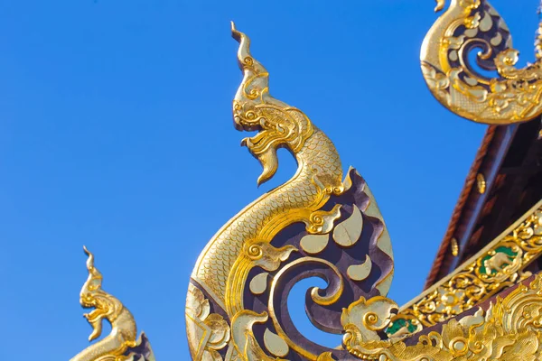 Beautiful Golden Thai Lanna Architecture: Naga wood carved at Chapel Roof Wat Inthakhin Sadue Muang, Chiangmai, THAILAND . — стоковое фото