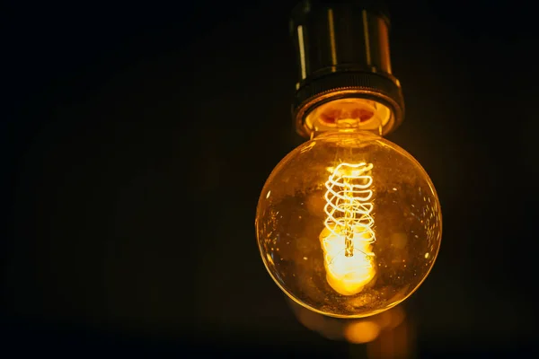 Single light bulb on dark background with space for text. — Stock Photo, Image