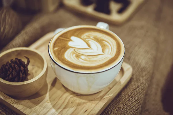 Café latte art servi sur plaque de bois décoré dans un café de couleur marron style vintage . — Photo