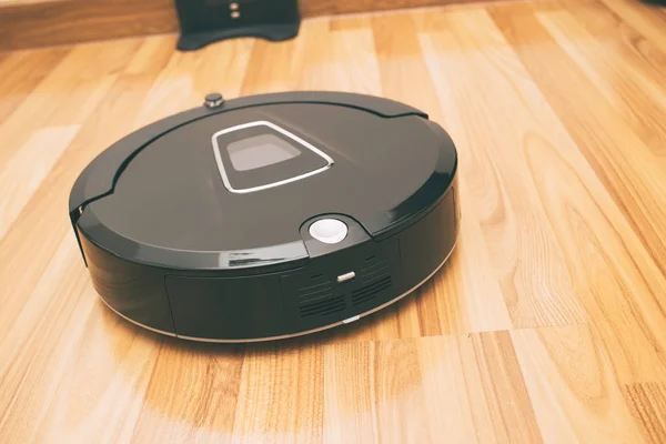 Robotic vacuum cleaner on laminate wood floor smart cleaning technology at home — Stock Photo, Image