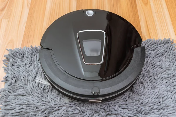 Robotic vacuum cleaner on laminate wood floor smart cleaning technology at home — Stock Photo, Image