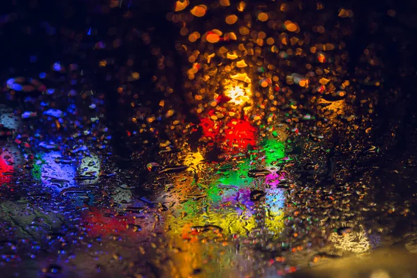 Chuva cair no windsheld noite chuvosa temporada com colorido urbano cidade borrão abstrato fundo — Fotografia de Stock