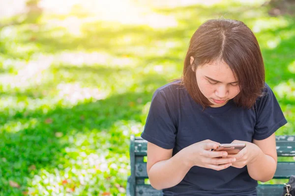 Ekrana bakarak park dikkat Smartphone kullanarak Asya teen