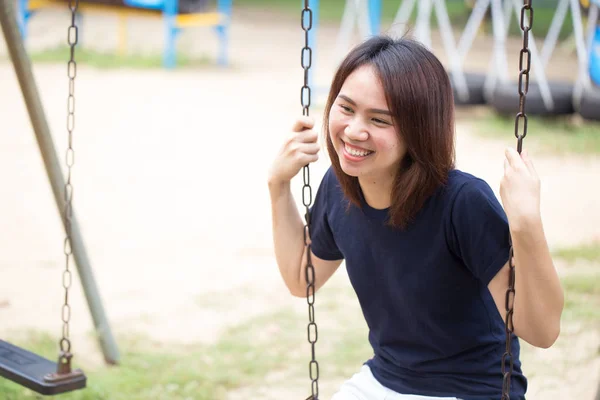 공원에서 놀이 스윙을 앉아 아시아 건강 한 십 대 착용 캐주얼 천 미소 — 스톡 사진